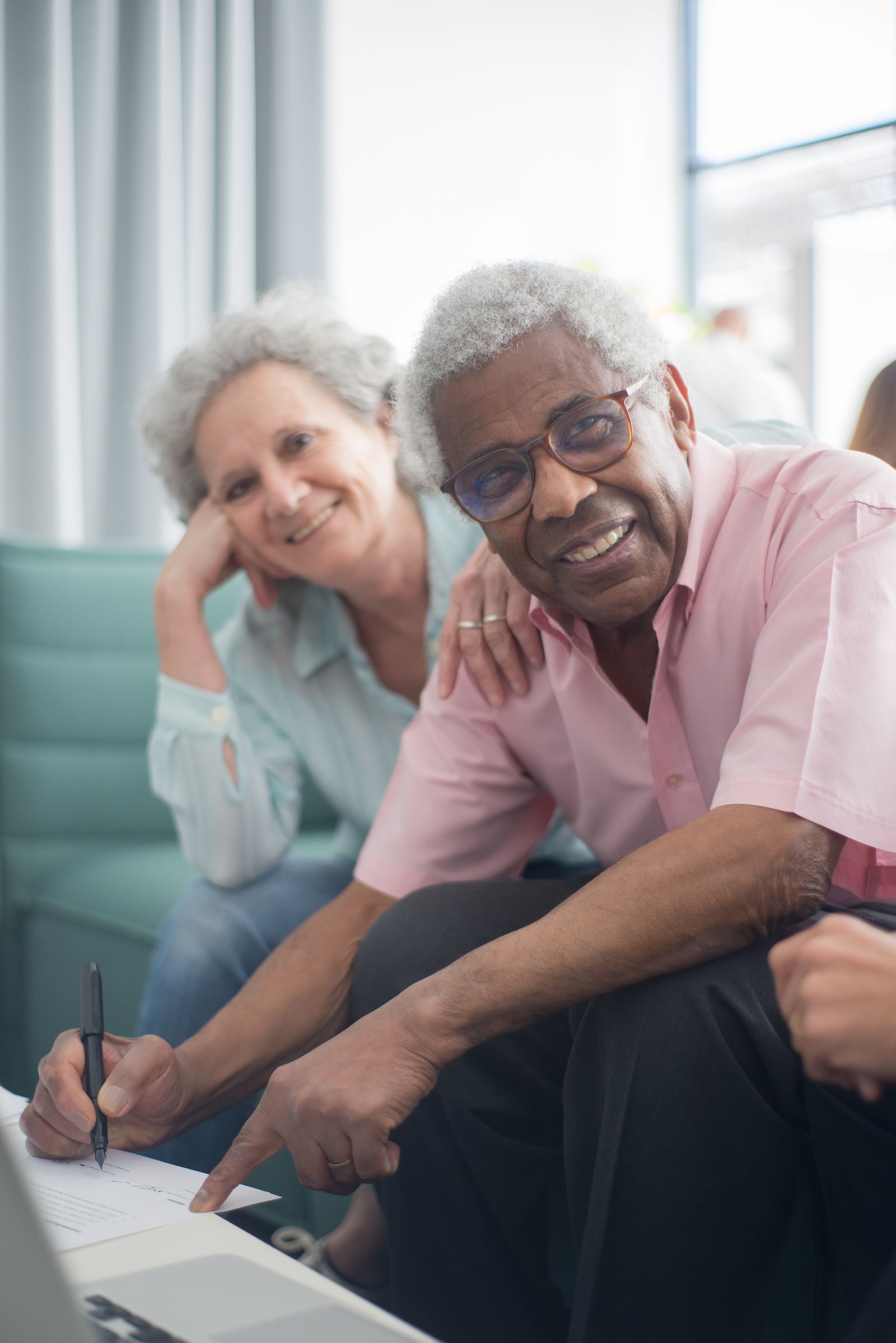 Older couple getting help reviewing their benefits paperwork